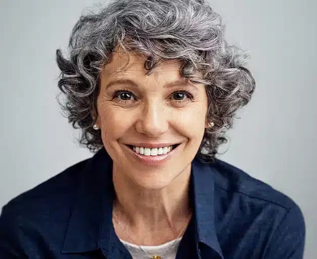 Older woman confidently smiling with dental implants in Altamonte Springs